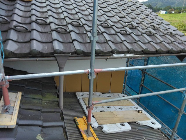上伊那郡飯島町：下屋根の上で軒樋を取り外している様子