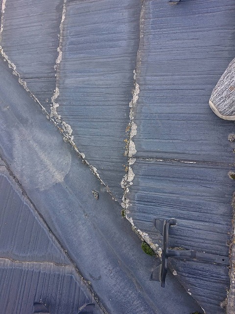 伊那市：スレート屋根の谷部で塗膜剥がれや苔が発生している様子