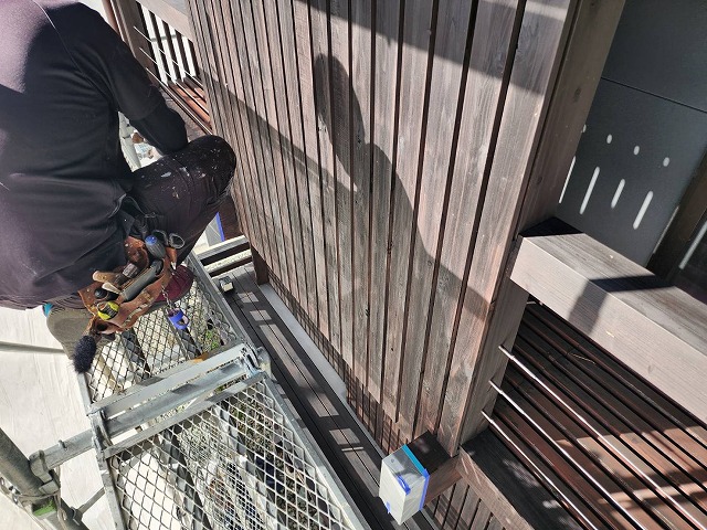 伊那市：足場の上で住宅屋外の木部に塗装する塗装工