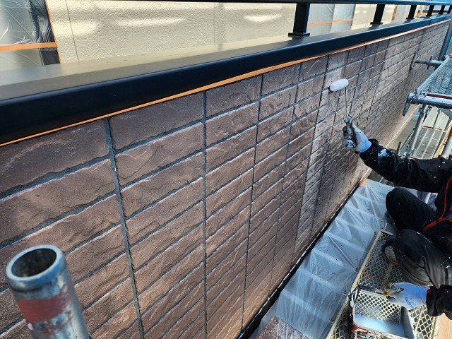 飯田市：ベランダ外壁への下塗りを行う塗装工