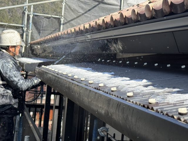 大桑村トミヤハイツ_雨樋を洗浄する作業員