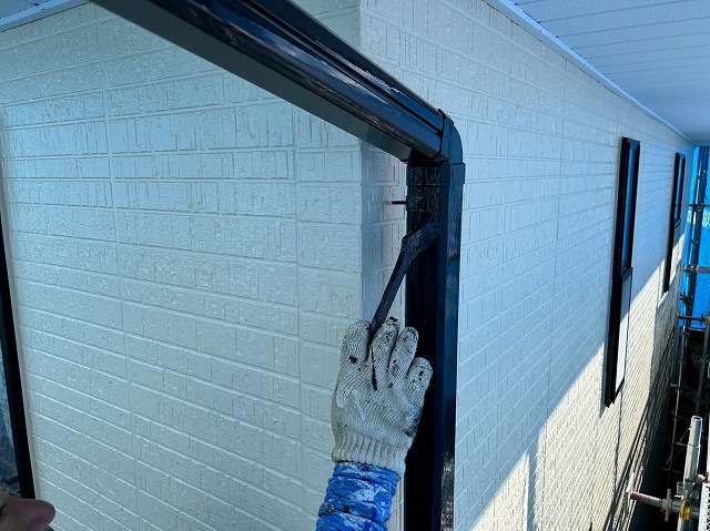 上伊那郡箕輪町：竪樋をハケを使って塗装する塗装工