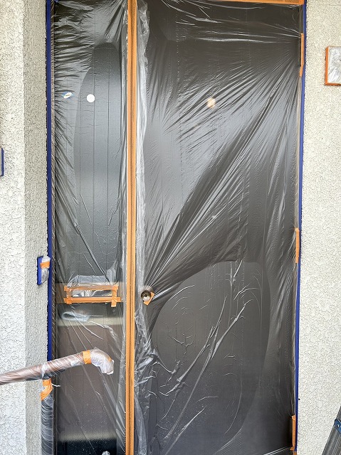 上伊那郡箕輪町：外壁塗装工事で玄関ドアに養生作業