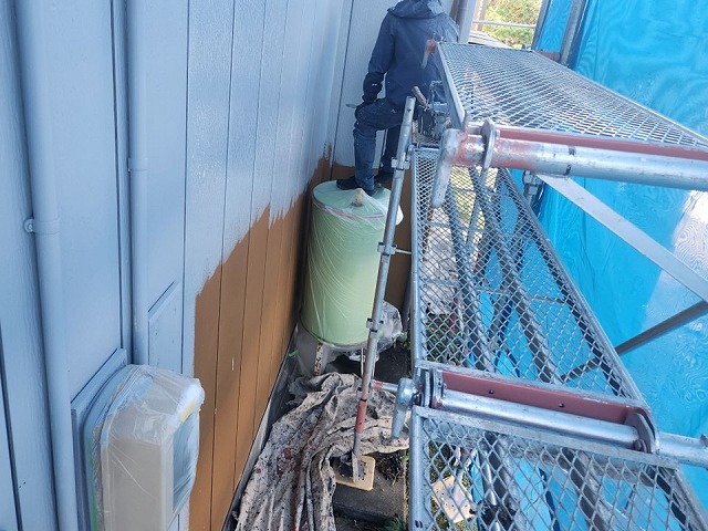 上伊那郡飯島町：足場の上で金属サイディングに塗装を行う塗装工